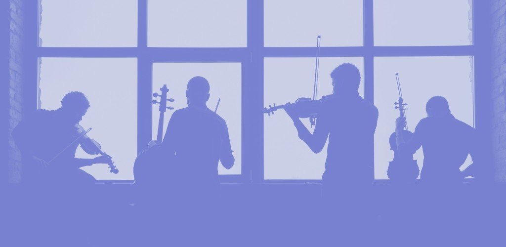Silhouette of a string ensemble rehearsing by a tall window